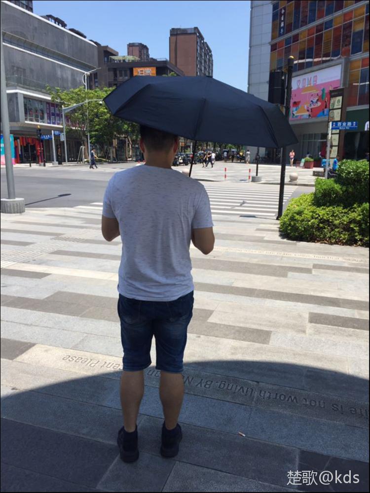 现在马路上撑伞的男人