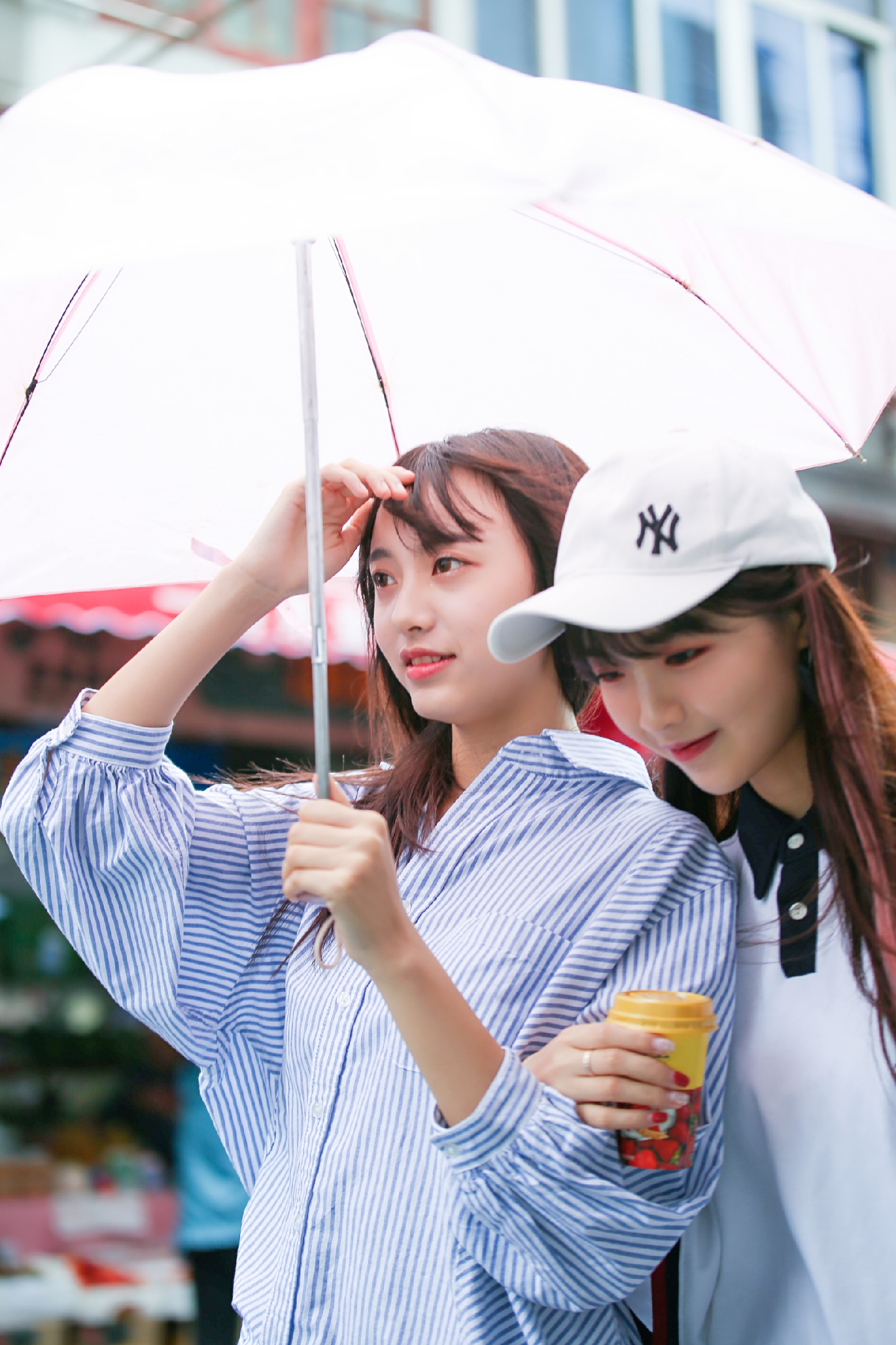 绵绵细雨上街沿打着伞的小姑娘